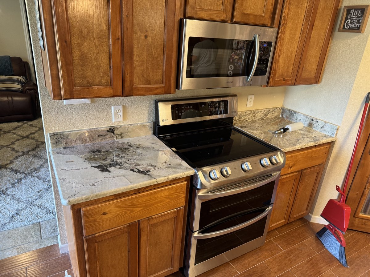 White Paradise granite kitchen countertop with farmhouse sink — Heart of Texas Granite & Marble