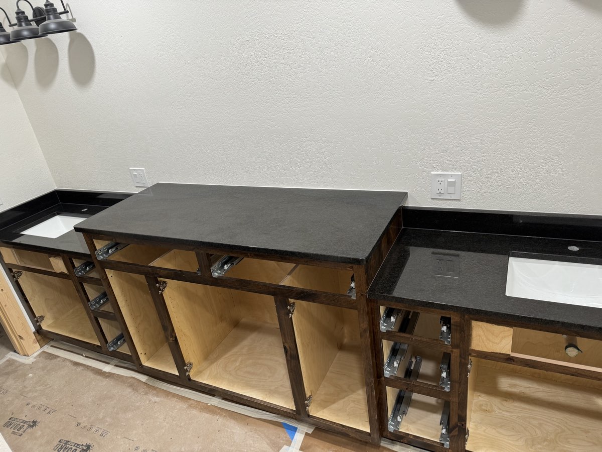 Black leathered granite countertops installed on custom open cabinets — new construction Central Texas