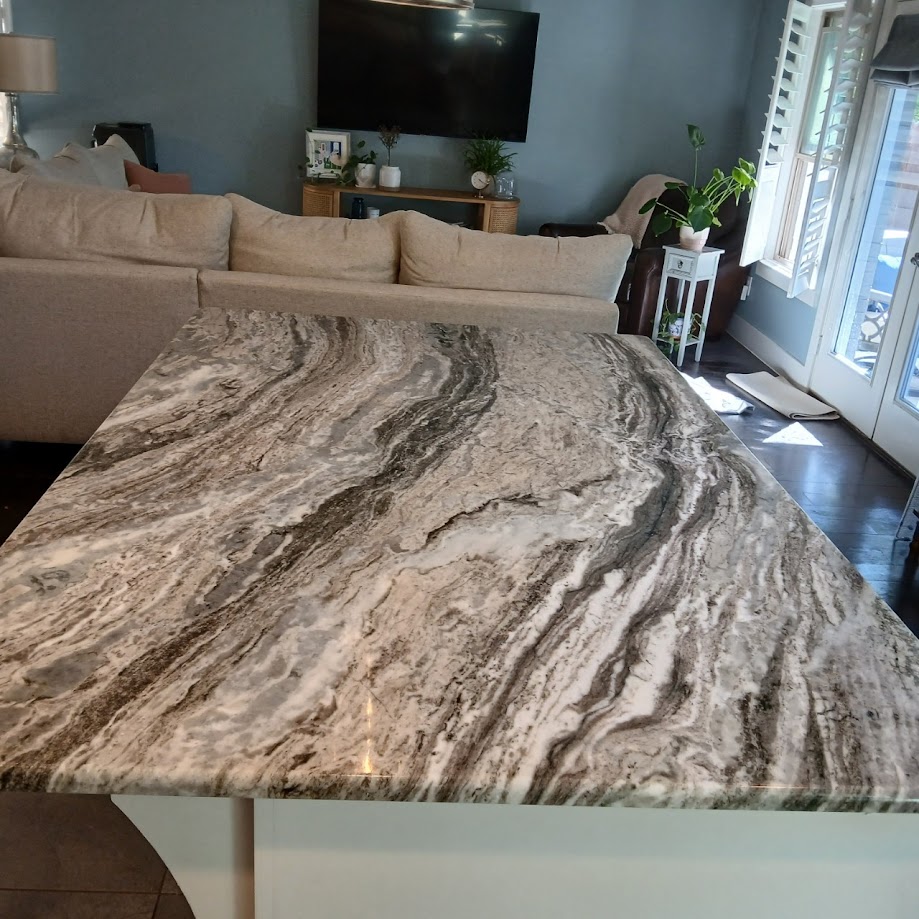 Brown Fantasy marble countertop close-up showing dramatic brown cream and grey flowing veins — Heart of Texas Granite & Marble
