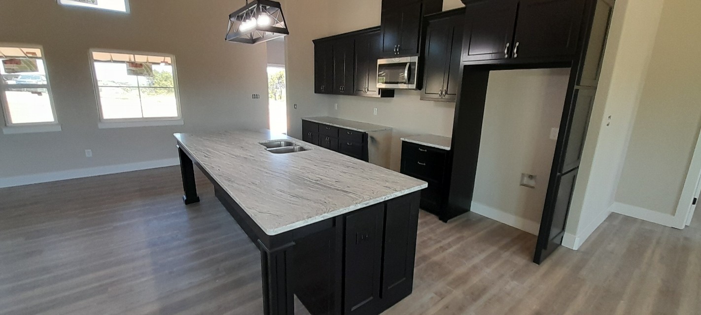 White marble kitchen island countertop with linear grey veining on dark espresso cabinets — new construction Central Texas