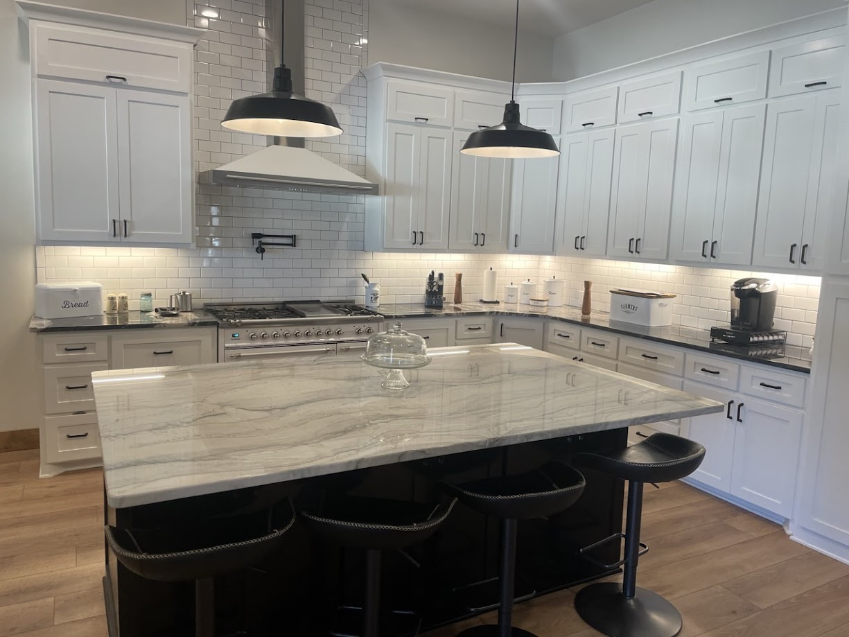 Infinity White quartzite kitchen island with bold white and grey flowing veins — white shaker cabinets Central Texas