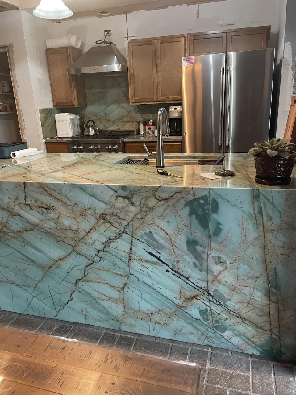 Sauipe quartzite kitchen island with full teal green and gold waterfall edge — Heart of Texas Granite & Marble